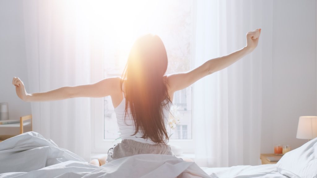 Senior woman sleeping peacefully in a cozy bed with a soft pillow and blanket.