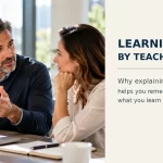 Professional explaining a new concept to a colleague as an example of learning by teaching.